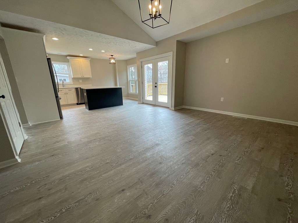 A spacious room with wooden flooring and a black countertop.