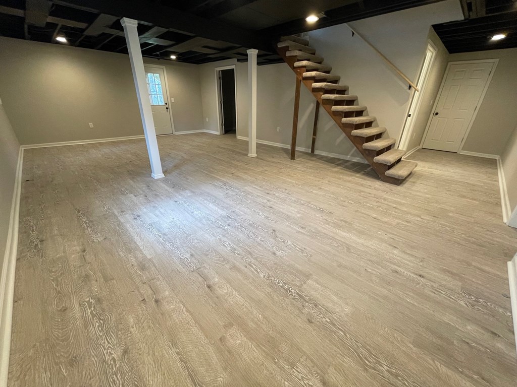 A room with wooden flooring and a staircase.
