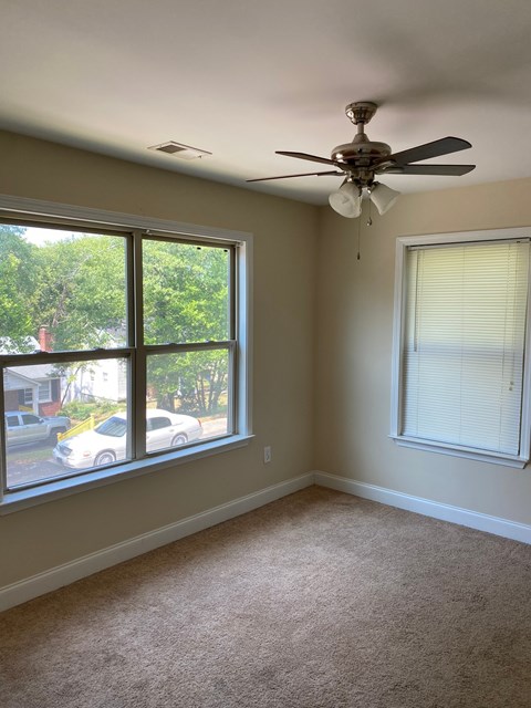 a living room with a ceiling fan and a large window
