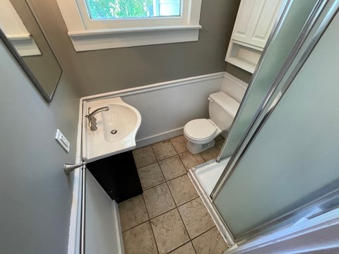 a small bathroom with a sink toilet and shower