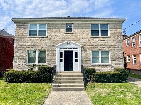 A grey stone house with a white door and windows.