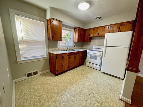 a kitchen with white appliances and wooden cabinets