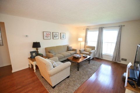 A living room with a couch, coffee table, and pictures on the wall.