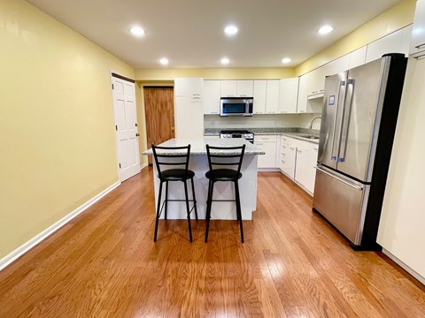 A kitchen with a table and chairs in the middle.