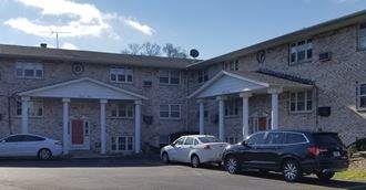two cars parked in front of a brick building