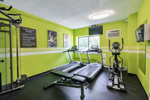 a gym with weights and a tv in it