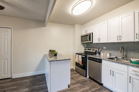 a kitchen with stainless steel appliances and white cabinets