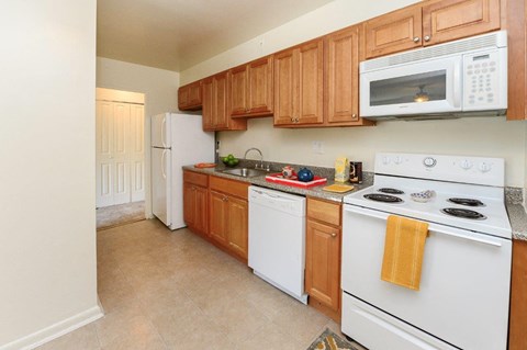 a kitchen with white appliances and wooden cabinets