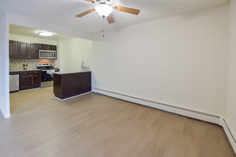 A room with a ceiling fan and wooden flooring.