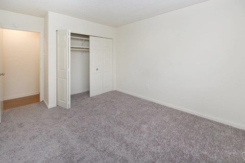 A room with a carpeted floor and a white door.