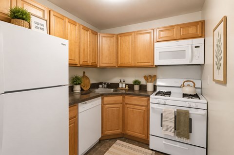 A kitchen with wooden cabinets and white appliances.
