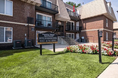 an apartment building with a sign in front of it
