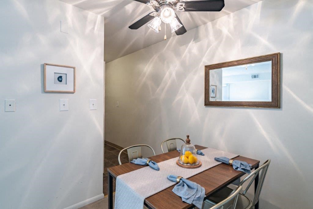 a dining room with a table and a ceiling fan