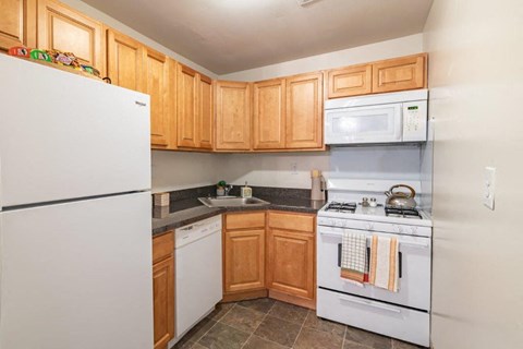 a kitchen with white appliances and wooden cabinets