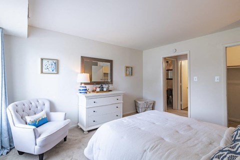 a bedroom with a bed and a chair and a dresser