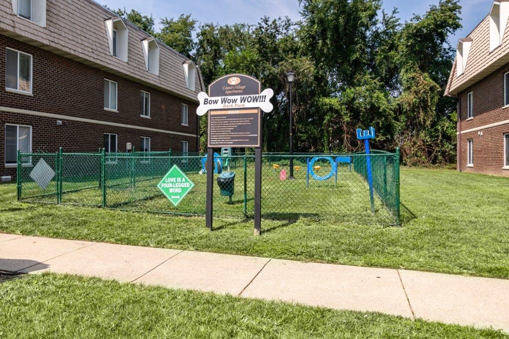 a sign in the middle of a yard with a fence