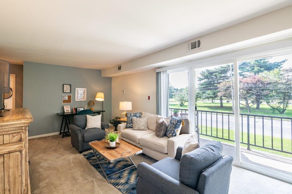 a living room with a couch and chairs and a large window