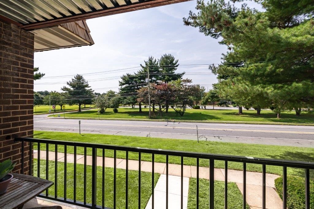 a balcony with a view of a street and trees