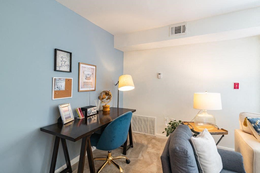 a living room with a desk and a couch