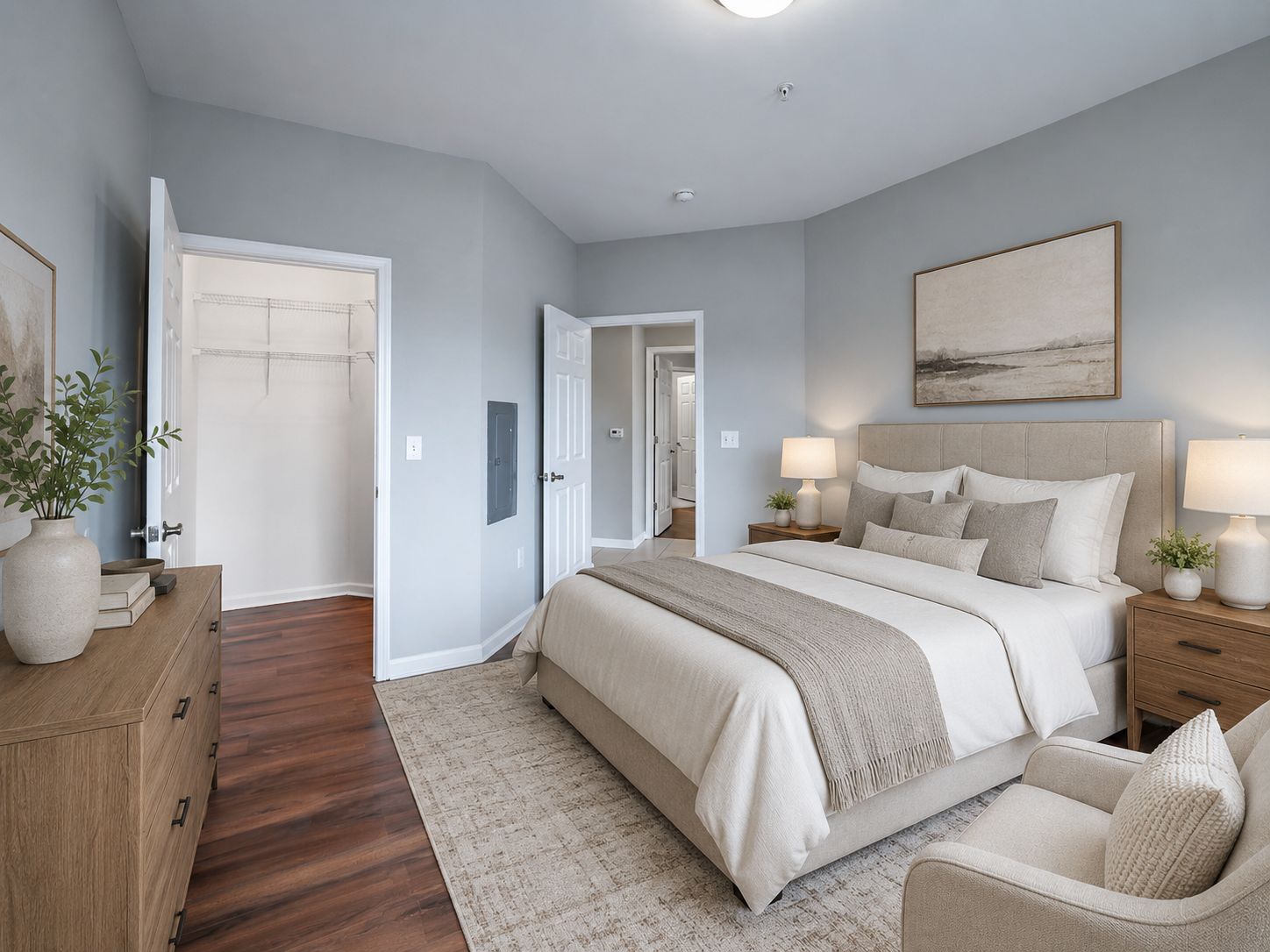 A bedroom with a large bed and a painting on the wall.