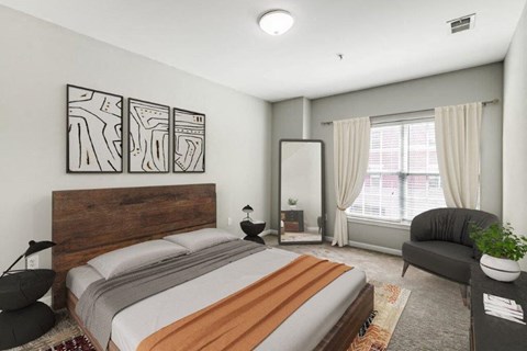 a bedroom with a bed and a chair and a mirror