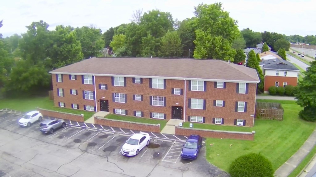 A parking lot in front of a red brick building.