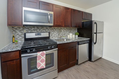 A kitchen with a stove, microwave, and refrigerator.