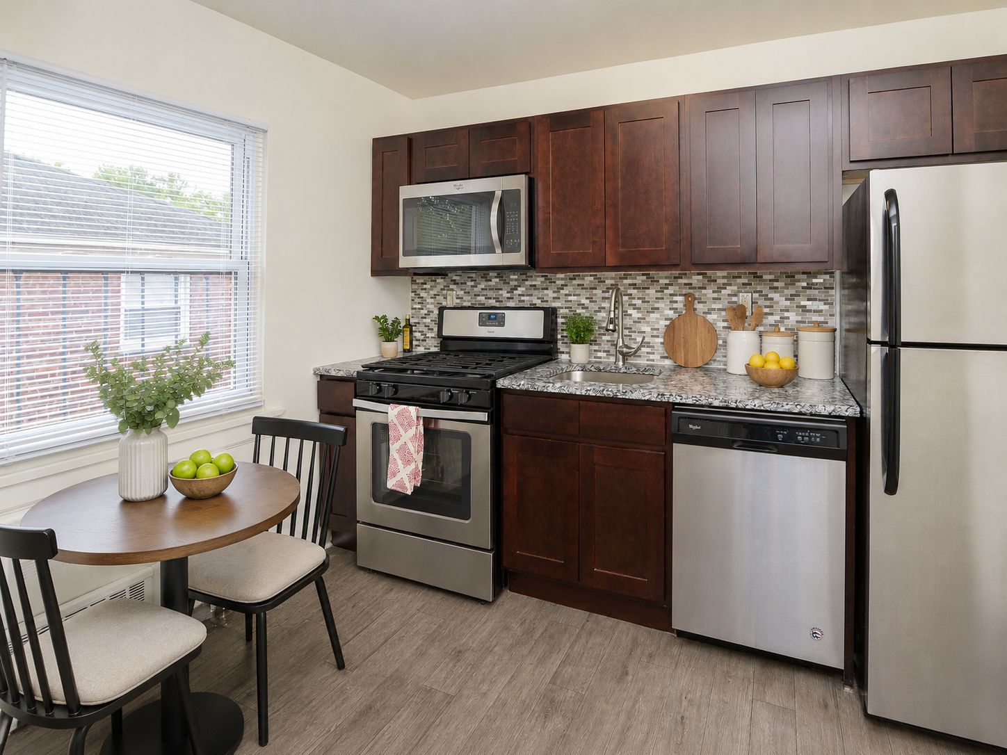 A kitchen with a table and chairs and a refrigerator.