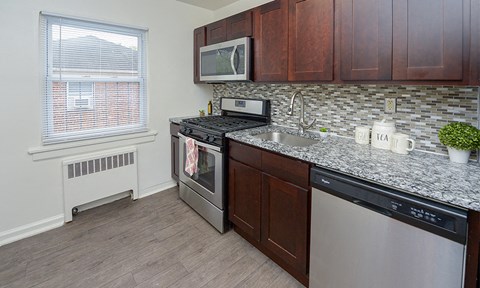a kitchen with granite countertops and stainless steel appliances and a window