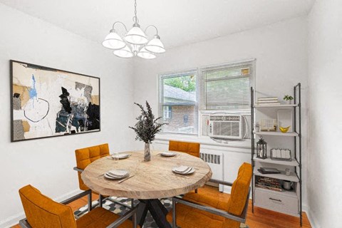 a dining room with a table and chairs and a window