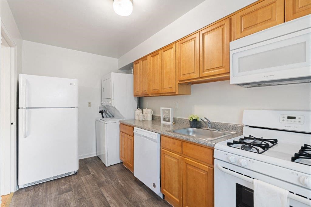 a kitchen with white appliances and wooden cabinets