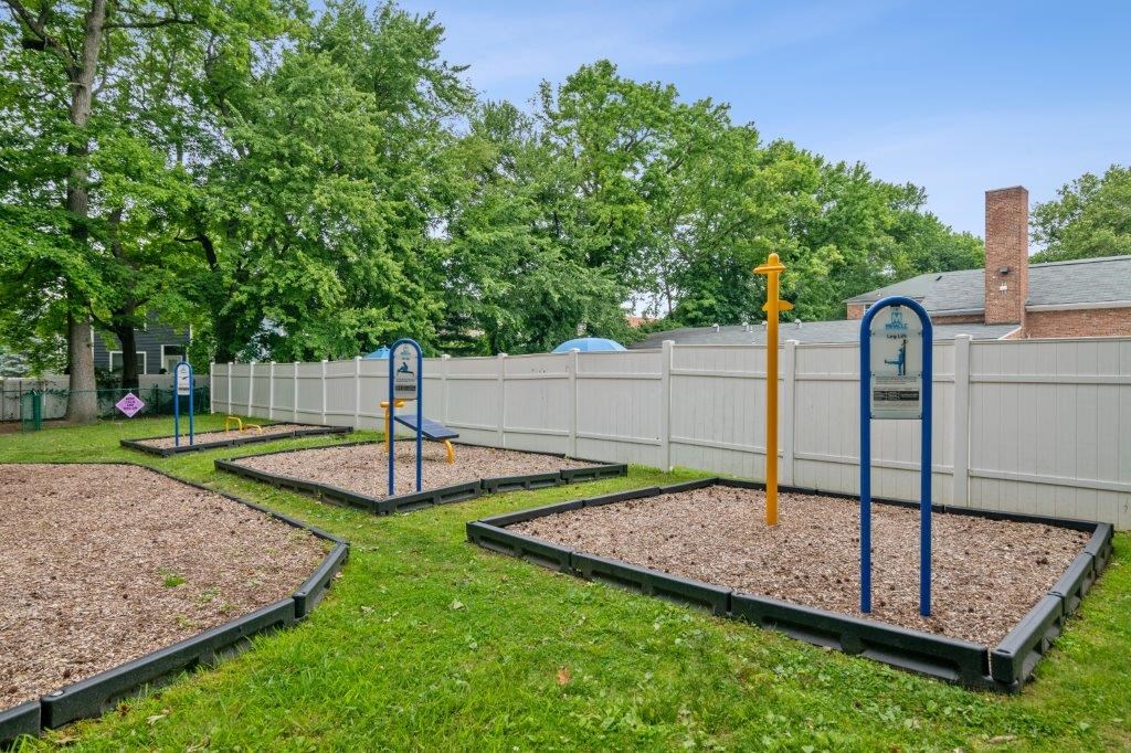 a playground in a fenced in area with playground equipment