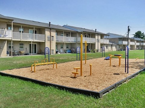 an empty playground in front of an apartment building