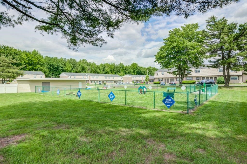 a fenced in dog park in front of a building