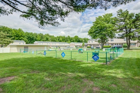 a fenced in dog park in front of a building