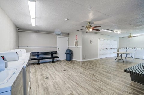 a room with a ceiling fan and desks and chairs