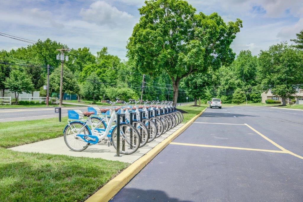a row of bikes parked at a bike rack on a street