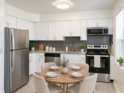 A modern kitchen with a table set for two.