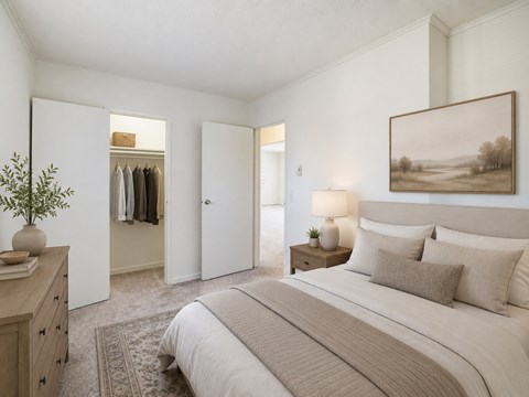 A bedroom with a large bed and a painting on the wall.