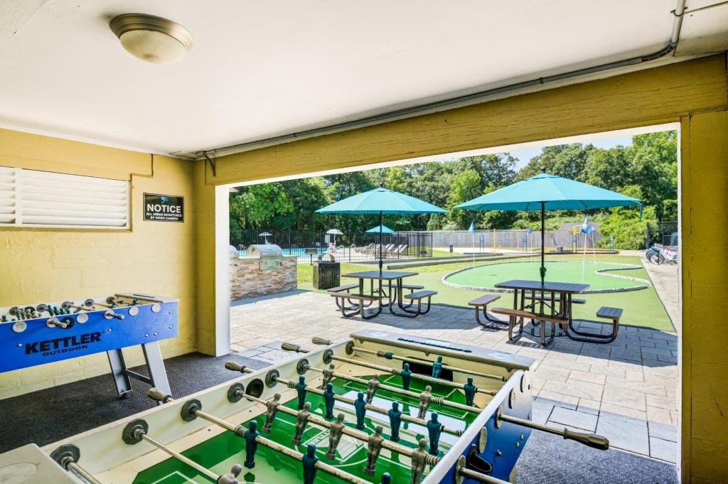 a games room with a pool table and umbrellas