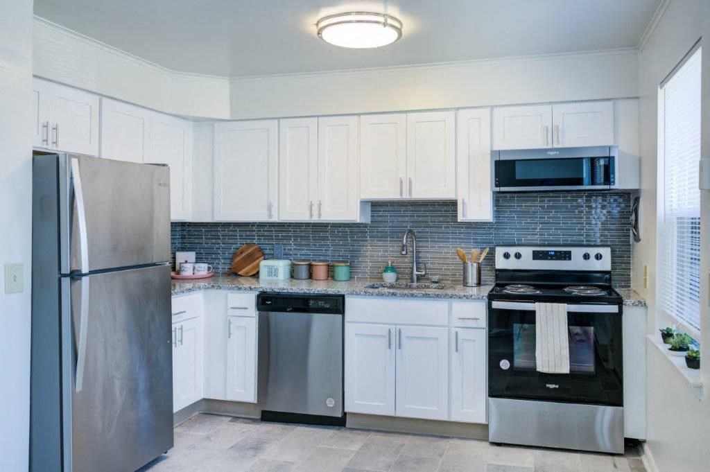 a kitchen with stainless steel appliances and white cabinets