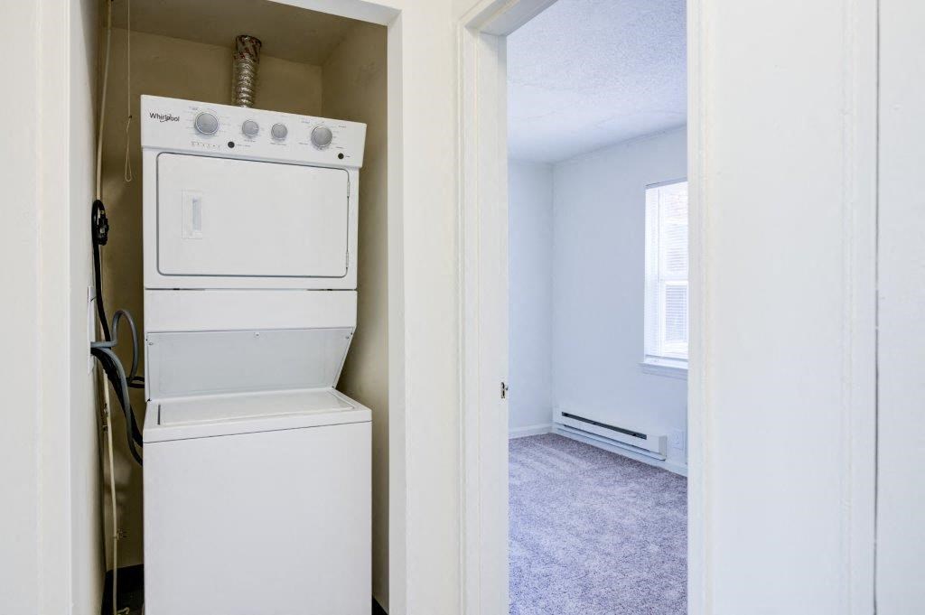 an empty laundry room with a washer and dryer in it