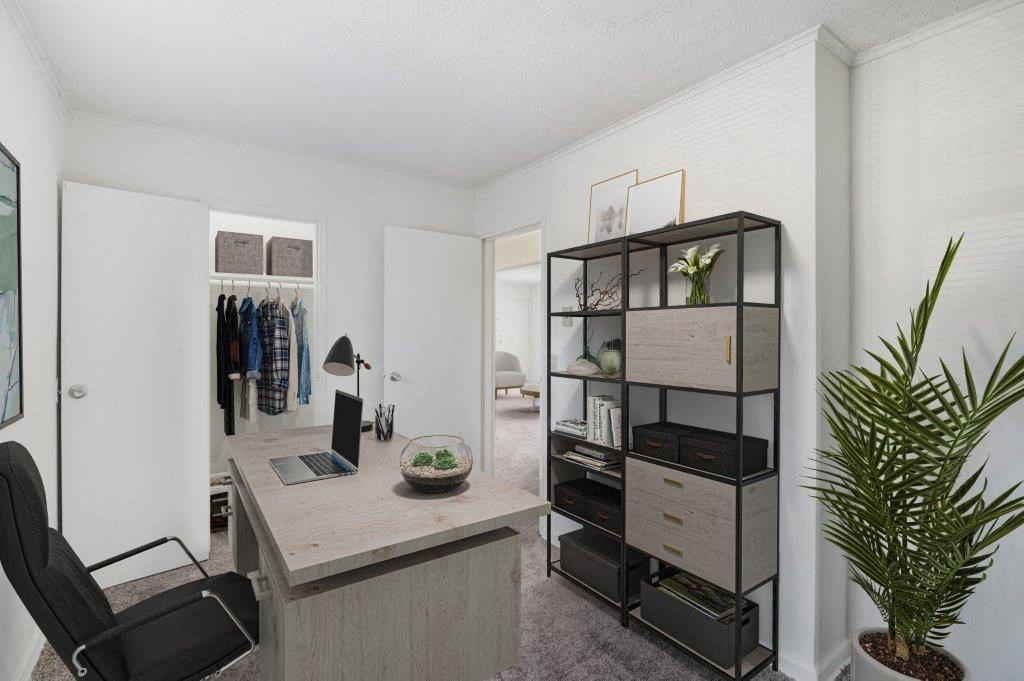 a home office with a desk and a closet