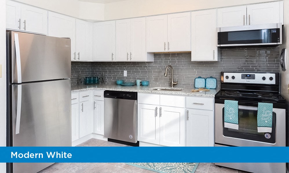 a modern white kitchen with stainless steel appliances and white cabinets