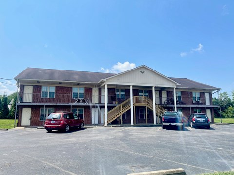 a parking lot in front of a building with cars