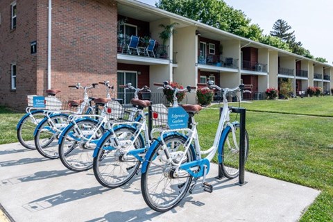 a row of blue bikes parked in front of a building