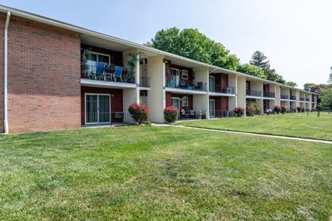 an apartment building with a grassy yard and balconies