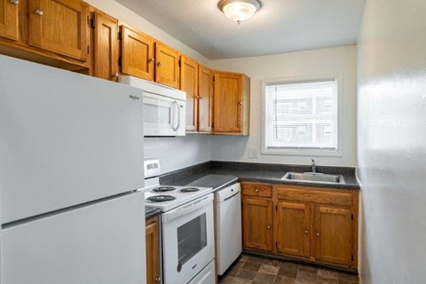 a kitchen with white appliances and wooden cabinets