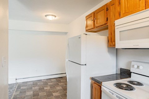 a kitchen with a white refrigerator and a stove