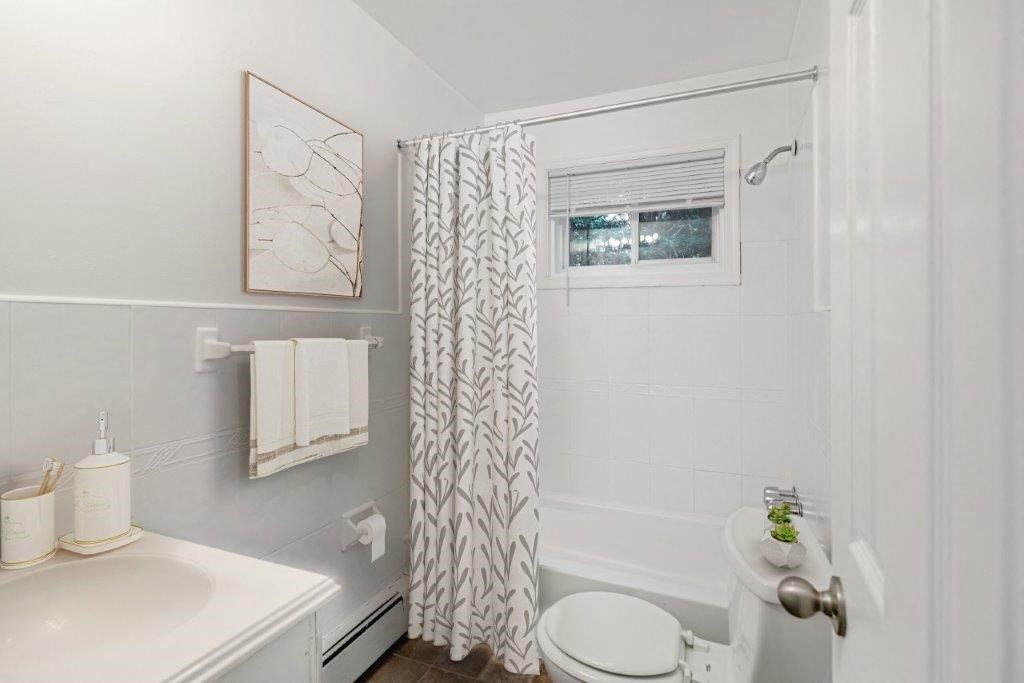 a bathroom with a shower curtain and a toilet and a sink